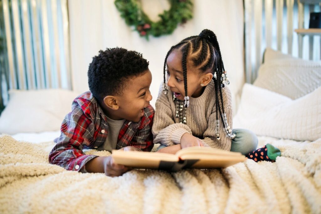 Two children reading a book together, sharing a joyful moment.